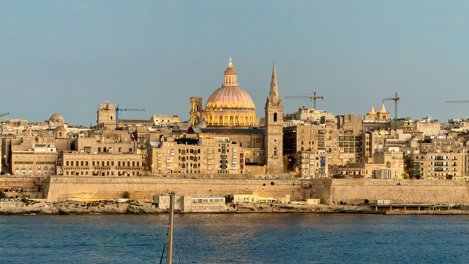 The Valletta skyline across the harbour at golden hour, Malta
